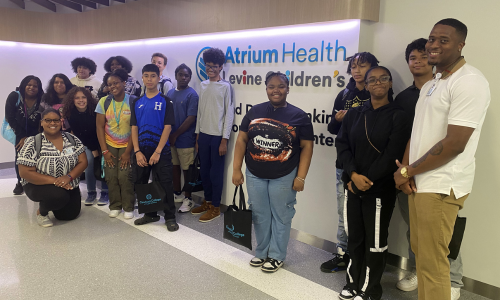  A group of students stand in front of an Atrium Levine Hospital sign